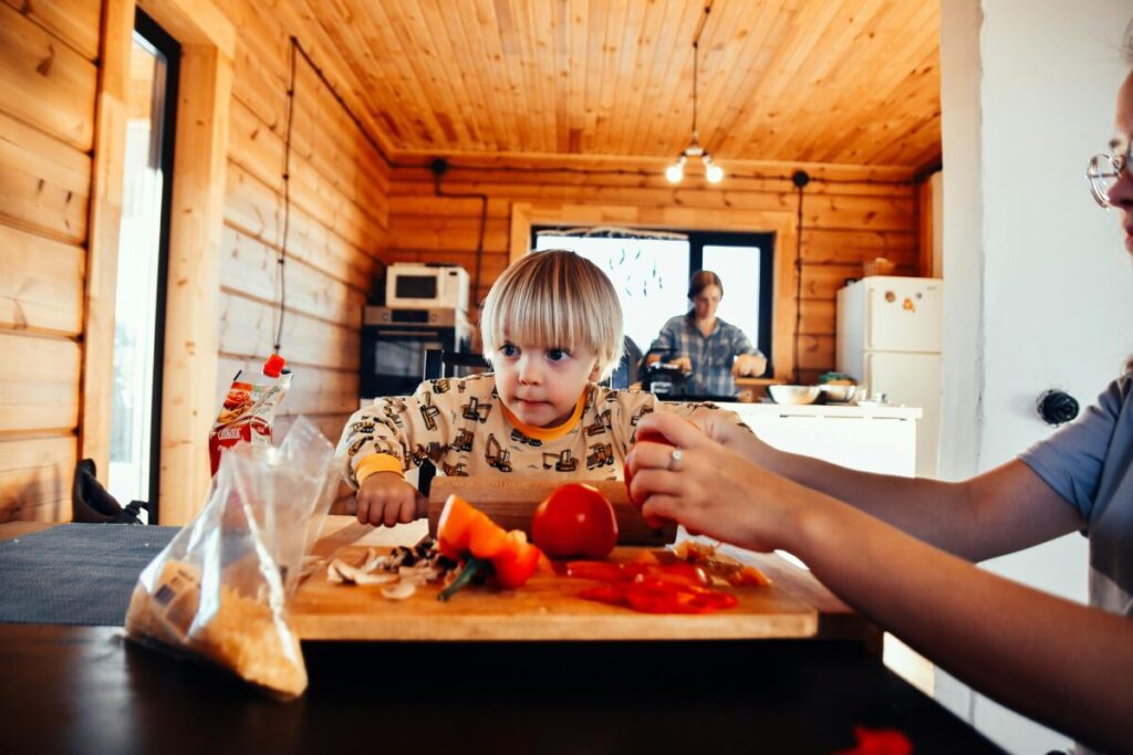 A toddler looking suspiciously at new food on their plate during the dinner battle