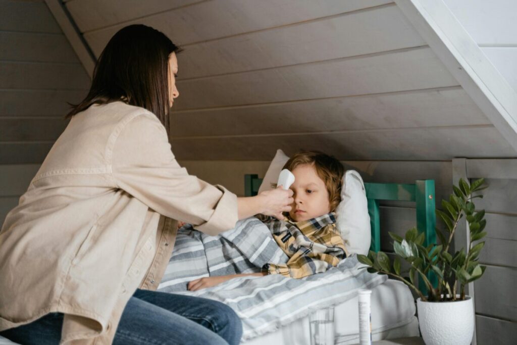 A mother checking her toddler's forehead and eyes to differentiate between an environmental allergy and a daycare cold