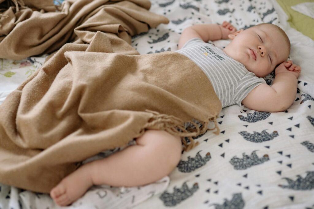 A restless baby moving in their sleep, illustrating why adding cereal to bottle to help baby sleep can backfire.