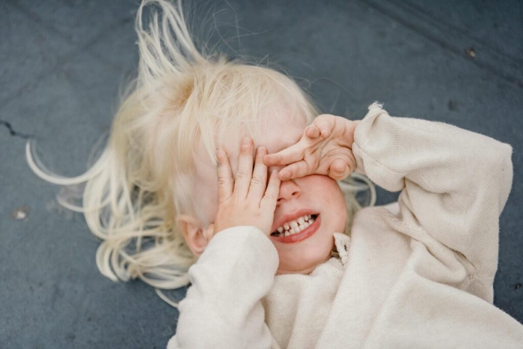 Parent sitting on the floor with a toddler having a meltdown, using calm parenting techniques to offer emotional support