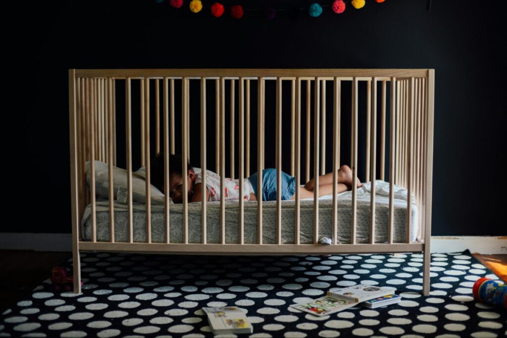 An exhausted mother rocking her distressed teething toddler at 3 AM, navigating tough sleep shifts and molar pain