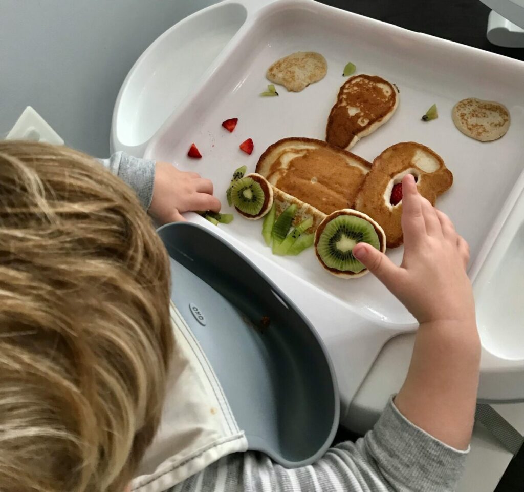 A colorful, deconstructed toddler bento lunch plate to help a toddler refusing to eat at 14 months try self-feeding