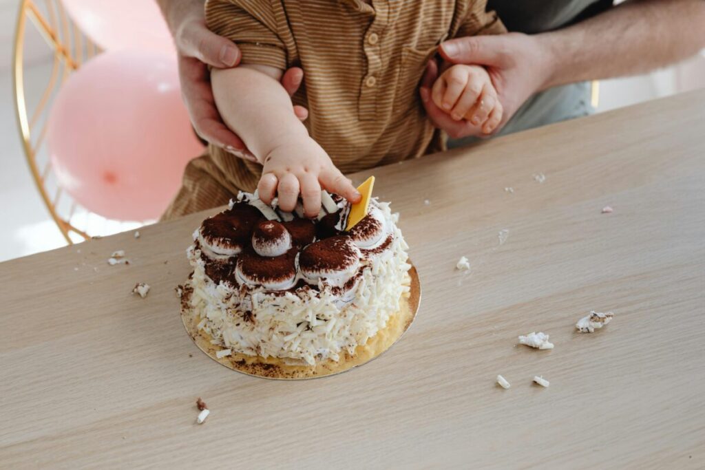 A messy toddler pushing a plate away and refusing to eat food in a high chair, showing typical 24 month old eating habits and picky eating