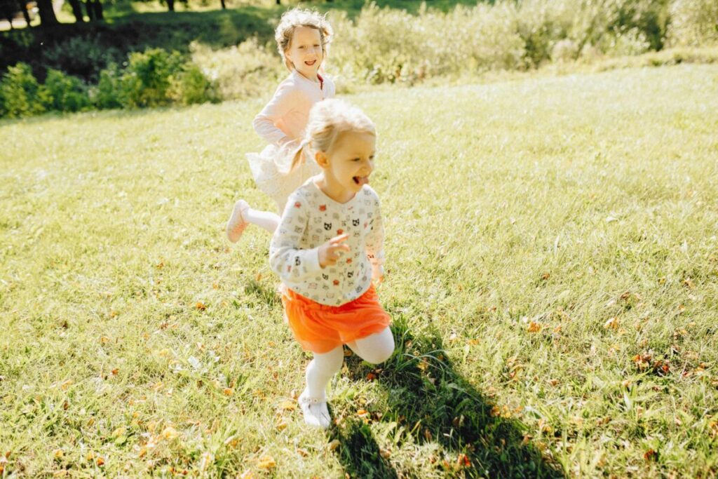 An active toddler running outside, displaying physical gross motor skills expected during 21 month milestones