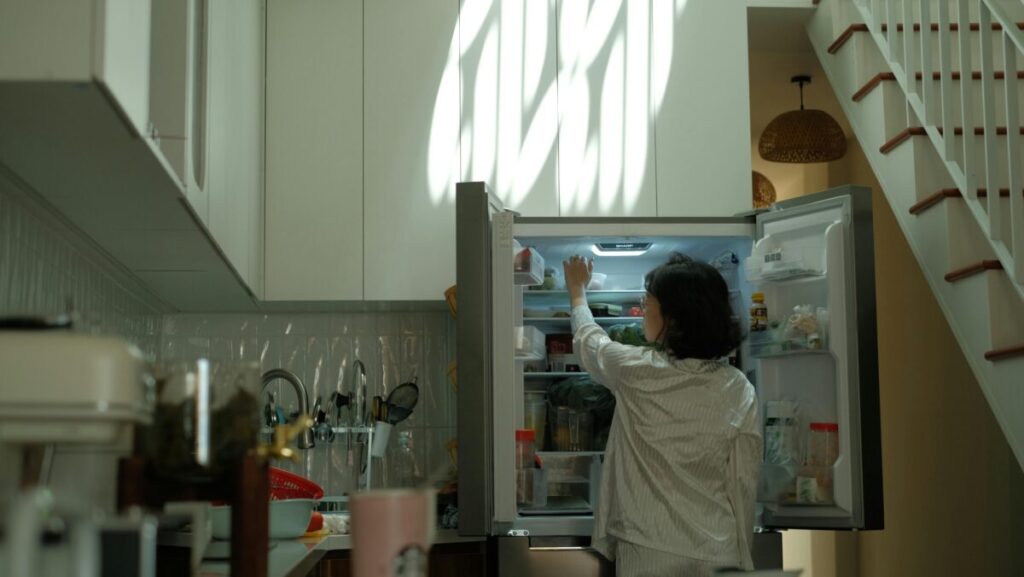 An open refrigerator lighting up a dark kitchen at night, representing the desperate 3 AM moments when a 14 month old feeding schedule goes out the window