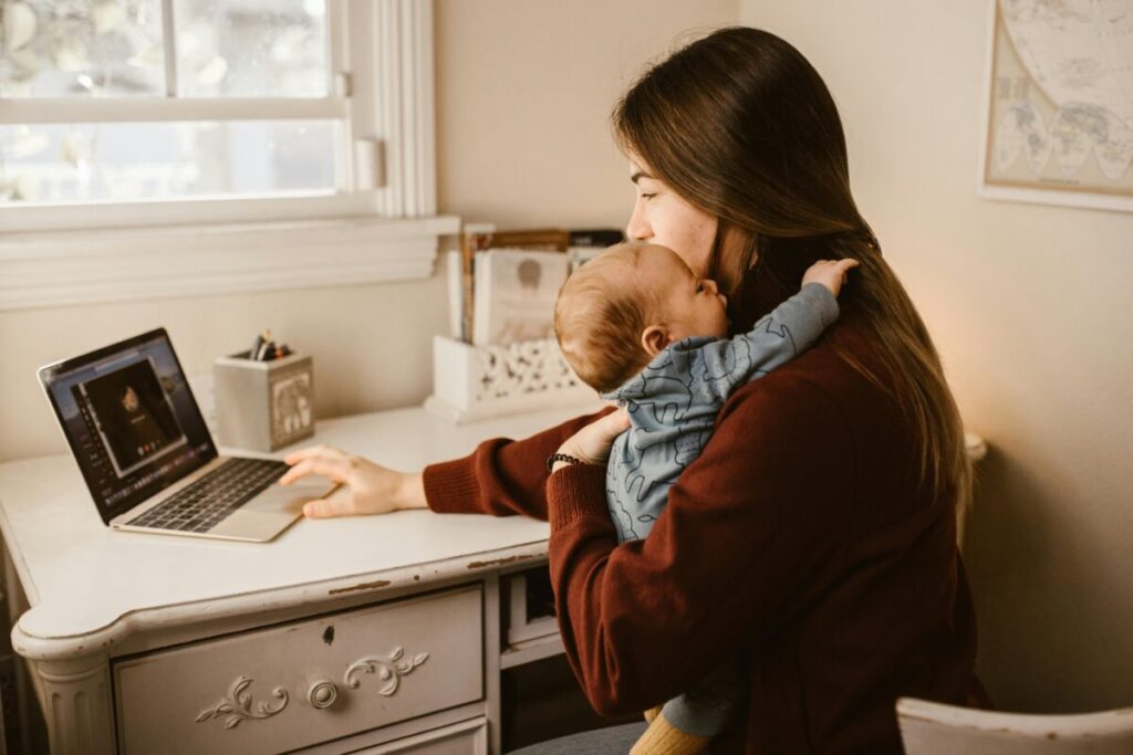 Mother embracing her baby while balancing returning to work after maternity leave