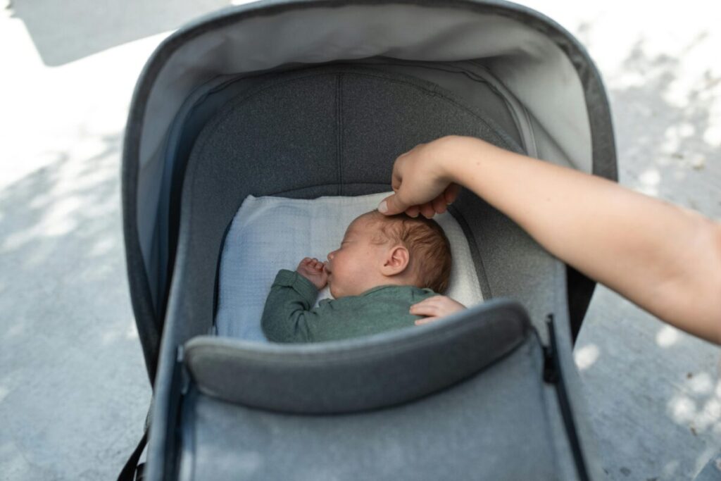 Managing baby sleep schedule while traveling in a new city, showing a baby in a stroller during a late-night walk when hotel sleep routines fail.