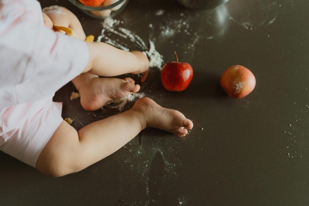 A toddler holding a single blueberry or piece of toast, reflecting the reality of what to feed a 16 month old who refuses to eat on some days