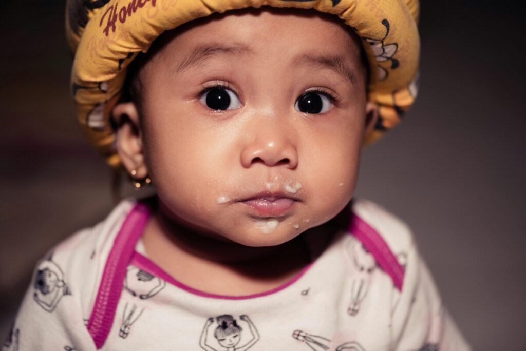 The messy reality of traveling with a baby for the first time, showing food stains and the lack of aesthetic perfection during a family trip