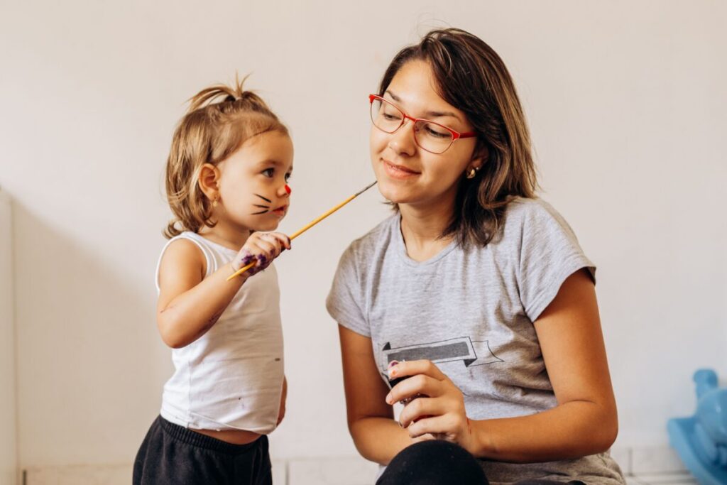 A mom talking face-to-face with her toddler, using simple communication to help build vocabulary and language skills.