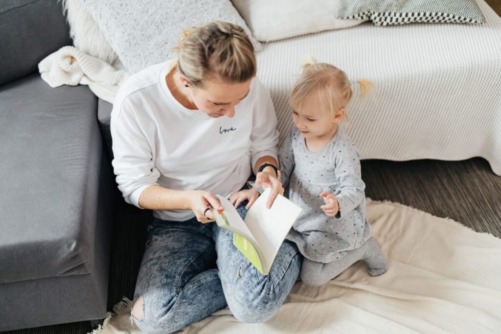 A mother reading a book with her toddler to encourage toddler talking and early language skills development.