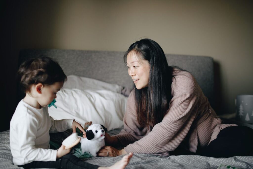 A mother watching her toddler closely, trying to understand their needs during the pre-speech stage of language development.