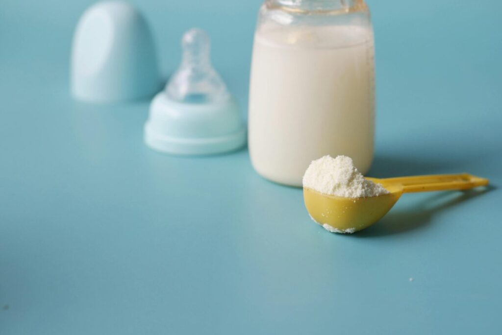 Close-up of toddler milk ingredients label showing corn syrup solids and added sugars