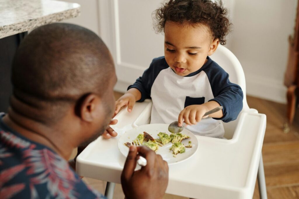 A baby safely handling food, showing that baby gagging on solids but not choking is a normal learning process