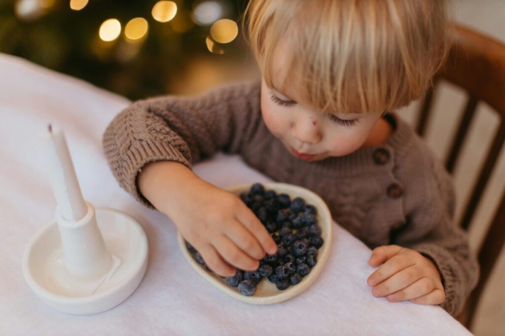 A mom offering healthy safe food options to her toddler, illustrating tips on how to handle 19 month old picky eating patterns without power struggles