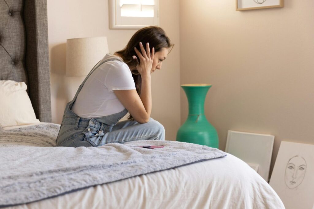 A woman taking a deep breath after a positive test, starting her first trimester checklist.
