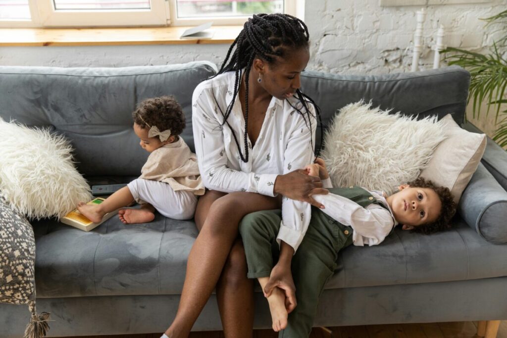 A patient mother comforting her crying child on the floor, dealing with intense 20 month old boundary testing behavior and big toddler emotions