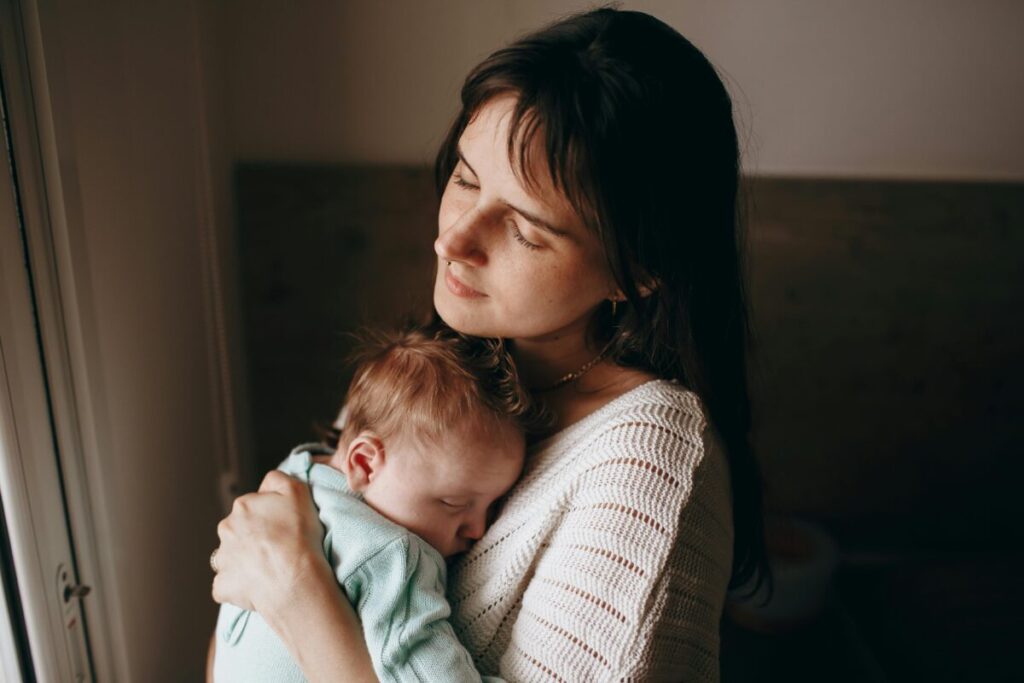 An exhausted mother resting after a busy day, having successfully managed her toddler's daily routine and figuring out how much whole milk should a 15 month old drink.