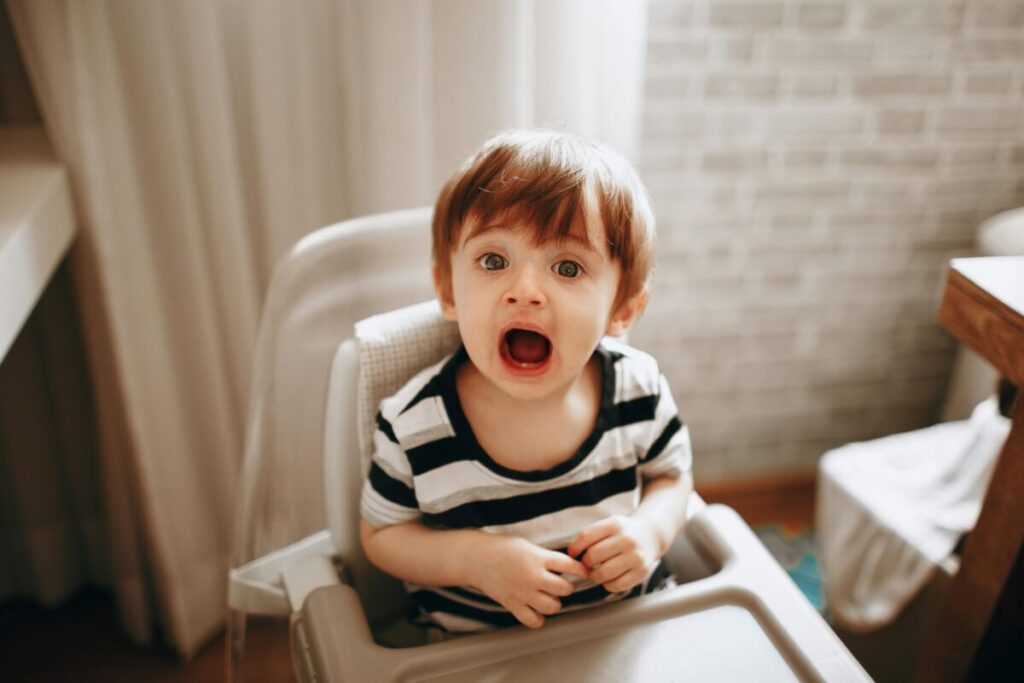 Overwhelmed toddler crying during mealtime showcasing sudden 23 month old behavior changes