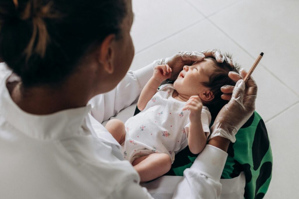 Parent carefully administering baby gas relief drops using a dropper