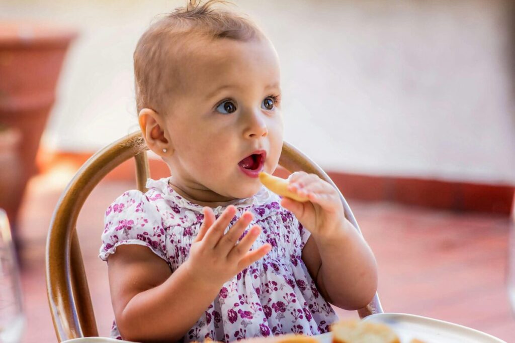 A high chair tray messy with avocado stains and food scraps, showing the reality of picky eaters during toddler nutrition struggles
