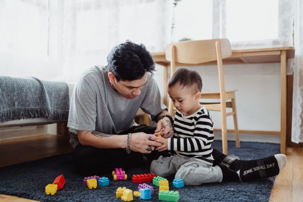 Patient parent sitting with a toddler to help them process big feelings and tantrums