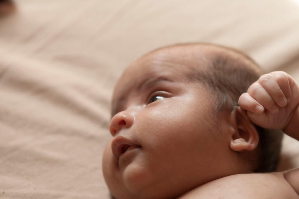 Fussy baby pulling ears as a hidden symptom while parent looks for baby teething relief that actually works