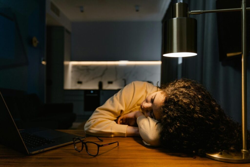 An exhausted mom working late on her laptop to fix errors while surviving 22 month old sleep regression and tantrums