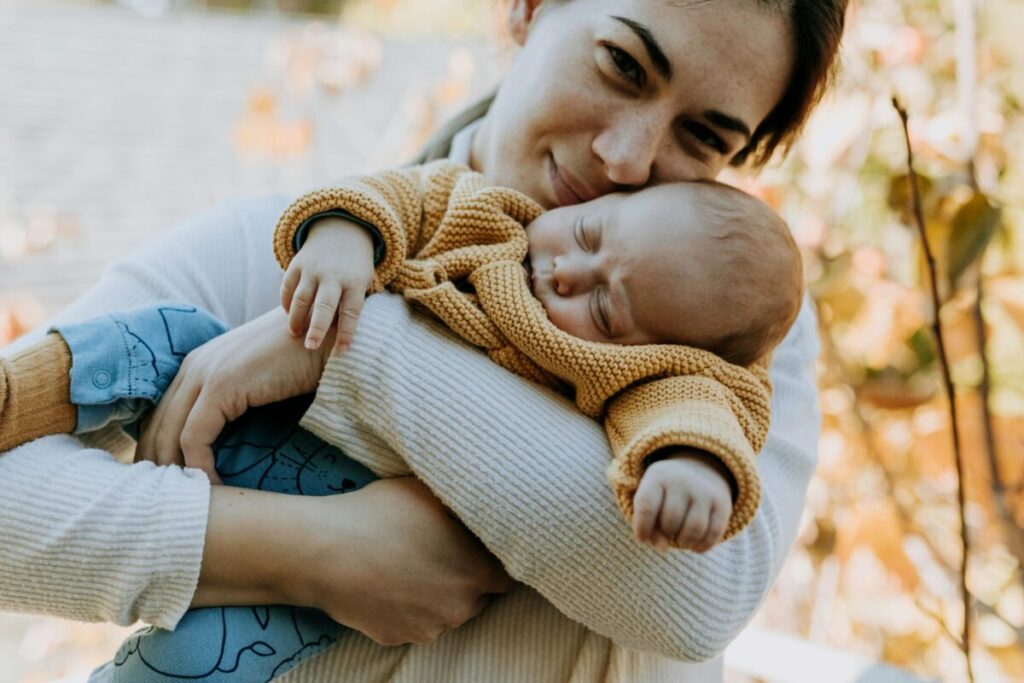 Mother holding her baby closely while learning how to keep baby hydrated in summer and understanding infant needs