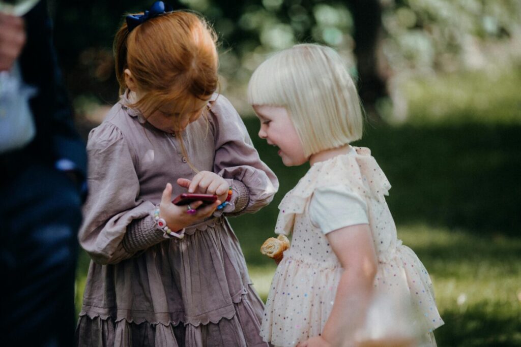 Two toddlers engaging in parallel play with toys side by side, showcasing typical social development as part of the 19 month milestones