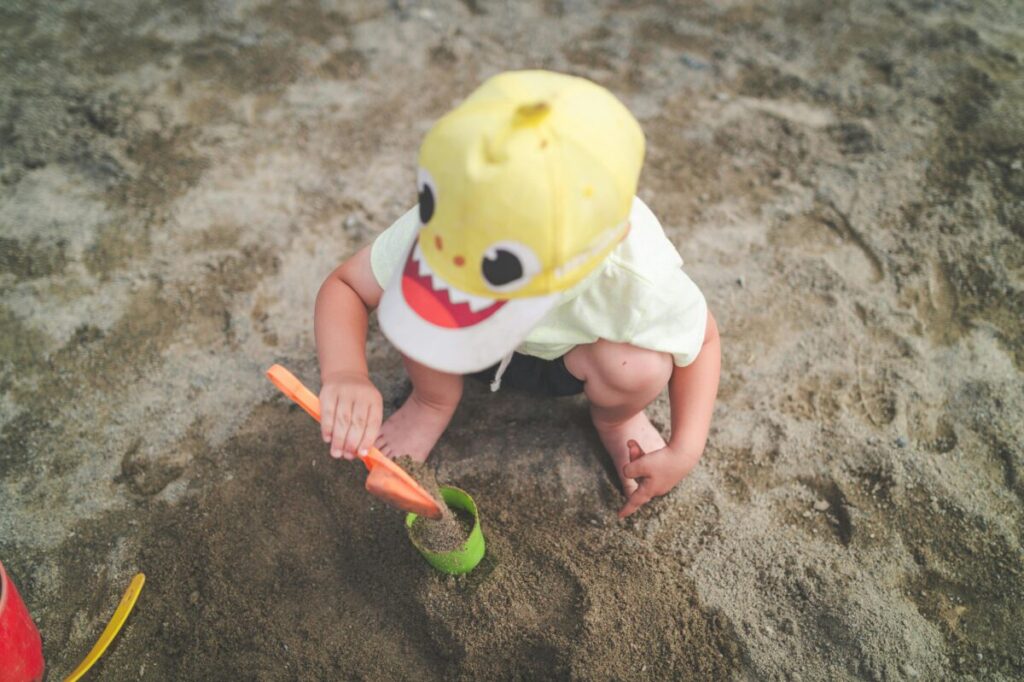 Toddler sharing struggles on the playground with a shovel