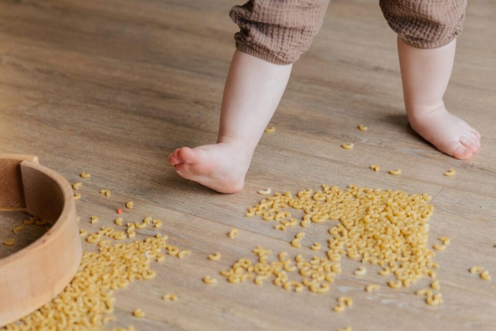 Frustrated toddler throwing a tantrum and crying flat on the kitchen floor