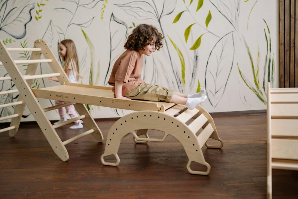 A fearless 22-month-old toddler climbing up on a kitchen chair, showing active gross motor skills and development