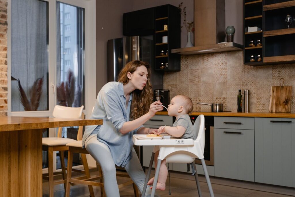 6-month-old baby exploring BLW egg recipes on a high chair tray during mealtime