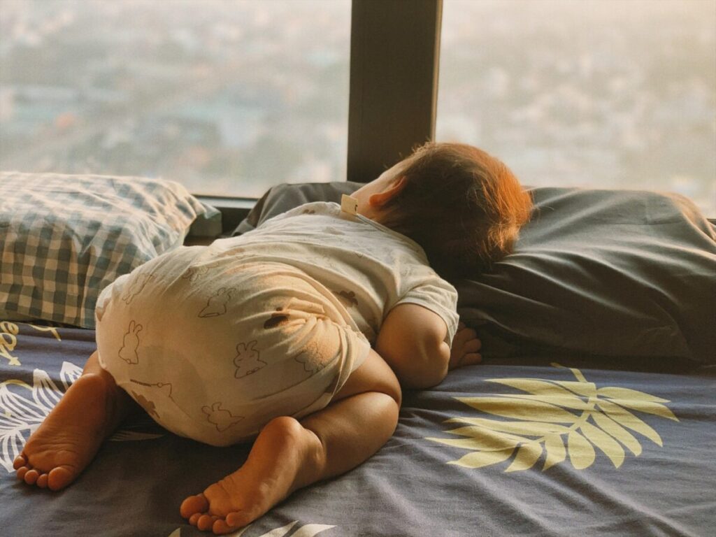 Calm toddler resting during a nap, signaling readiness for crib to bed transition
