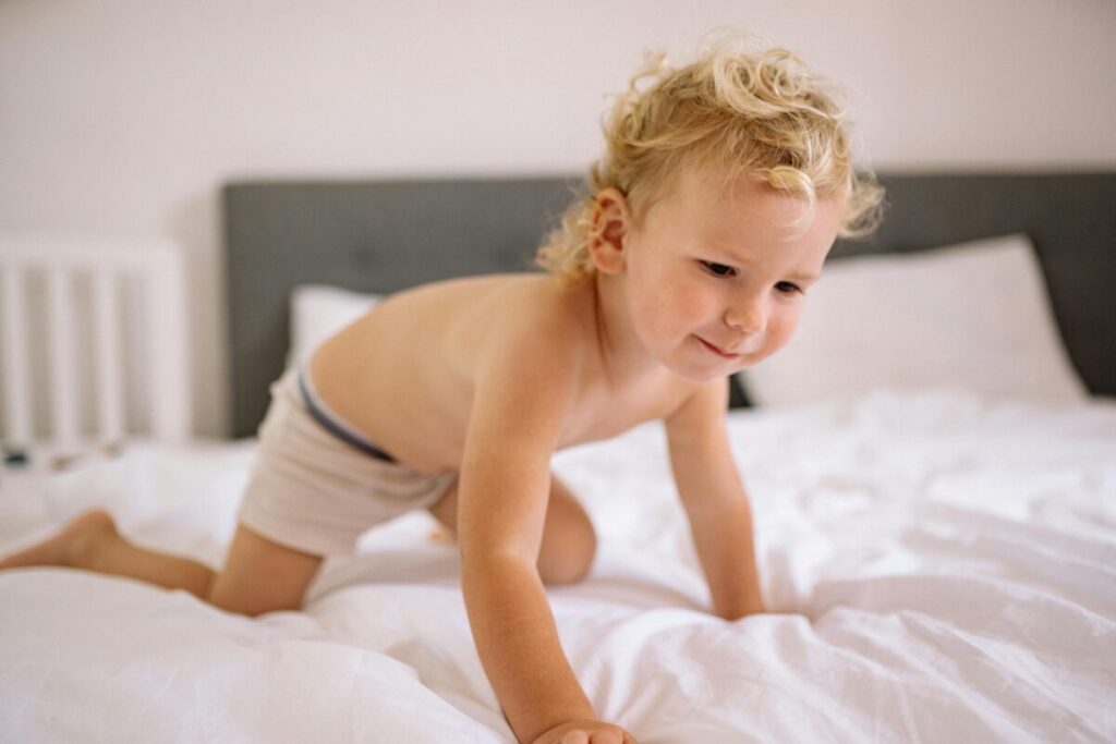 Curious toddler showing interest in a big kid bed for crib to bed transition